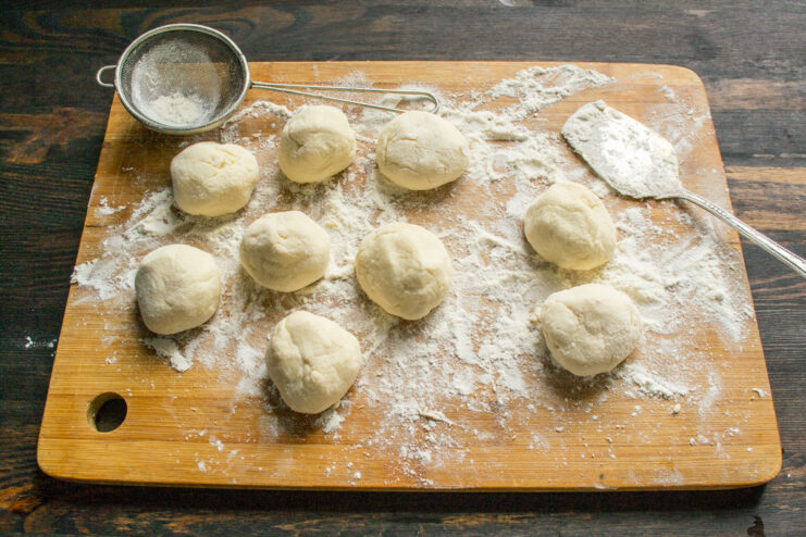 Coating the syrniki in flour Rolled syrniki dough balls coated in flour