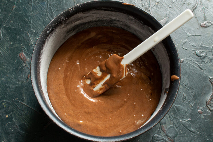 Batter in the pan Chocolate batter spread evenly in a round baking pan