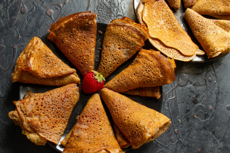 Folding and serving chocolate crepes Folded chocolate crepes shaped into triangles served with berries
