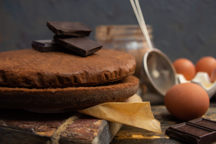 Freshly baked chocolate genoise sponge cake on a wooden board
