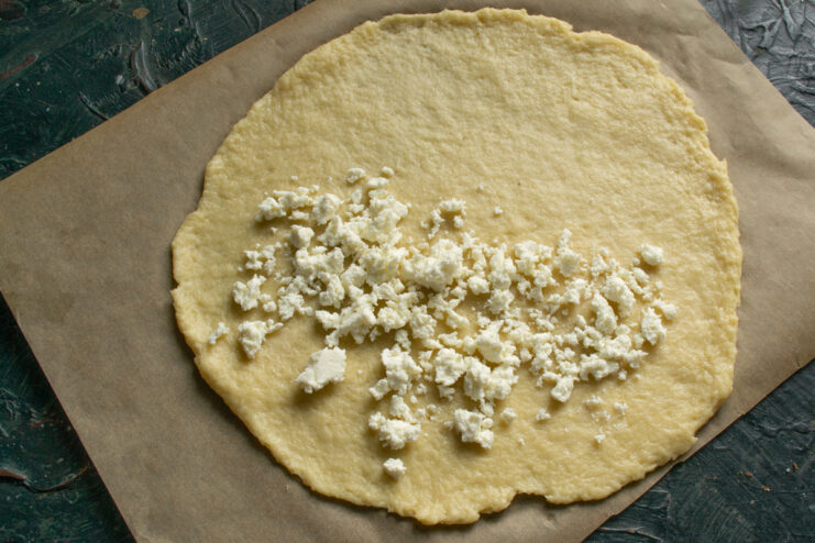 Adding The Farmer's Cheese A layer of dry farmer's cheese spread on one half of the dough circle