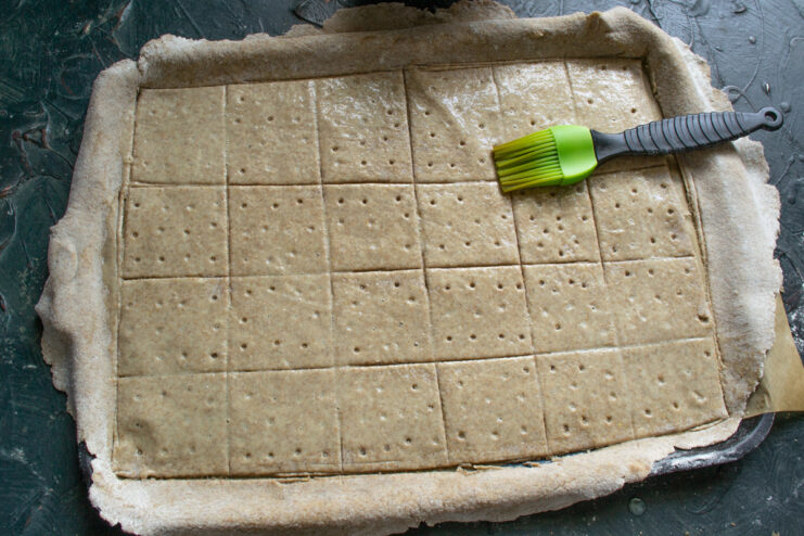 Egg wash application Brushing beaten egg wash over the surface of rolled rye dough