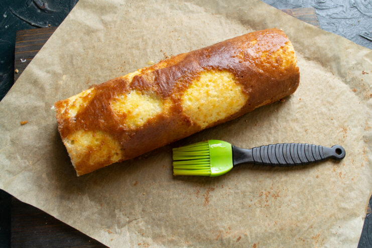 Brushing the roll Brushing the top of the rolled cake with melted butter