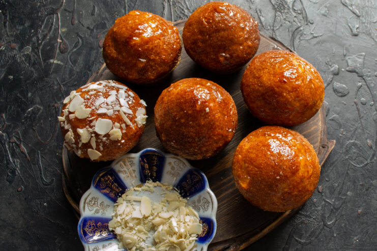 Glazing with apricot jam Glazing muffin tops with apricot jam to secure the chopped nut topping