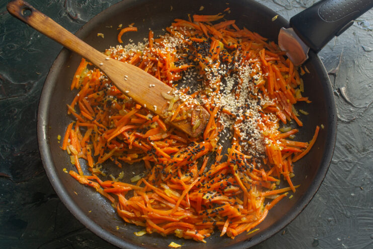 Sprinkling Sesame Seeds Mixed black and white sesame seeds sprinkled over a cooked vegetable marinade.