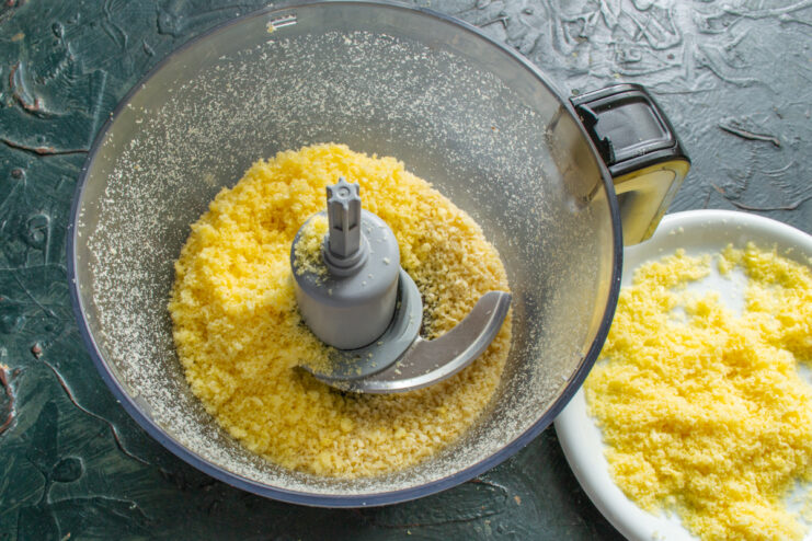 A mixture of crushed sweet corn puffs and almonds in a blender