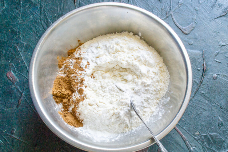Mixing dry ingredients Flour, baking powder, and cinnamon mixed in a bowl