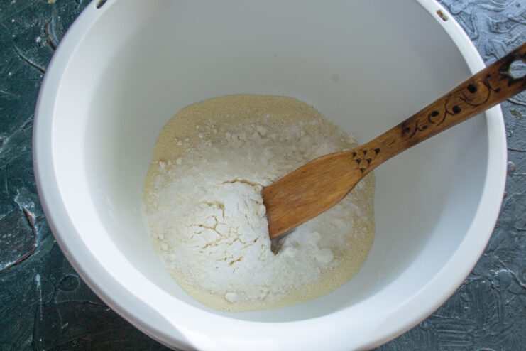 Mixing The Dry Ingredients Whisking semolina, flour, and baking powder together in a white mixing bowl
