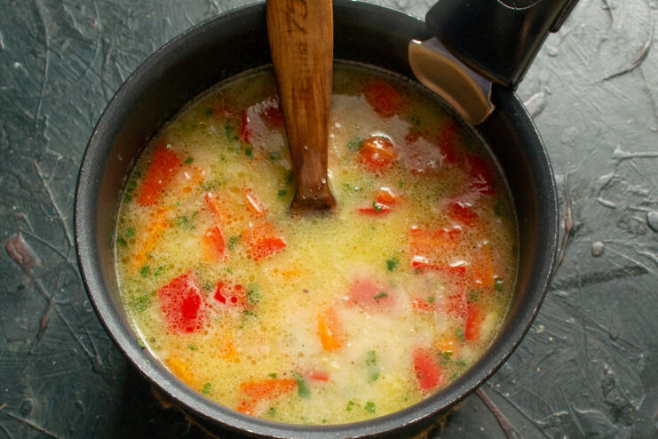 Thickening the soup Pouring thickened flour sauce into the soup pot