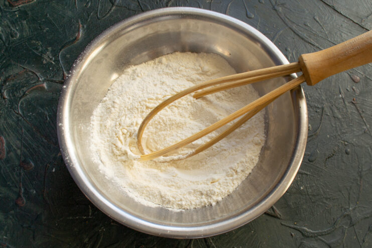 Mixing Dry Ingredients Whisking flour and baking powder together in a bowl
