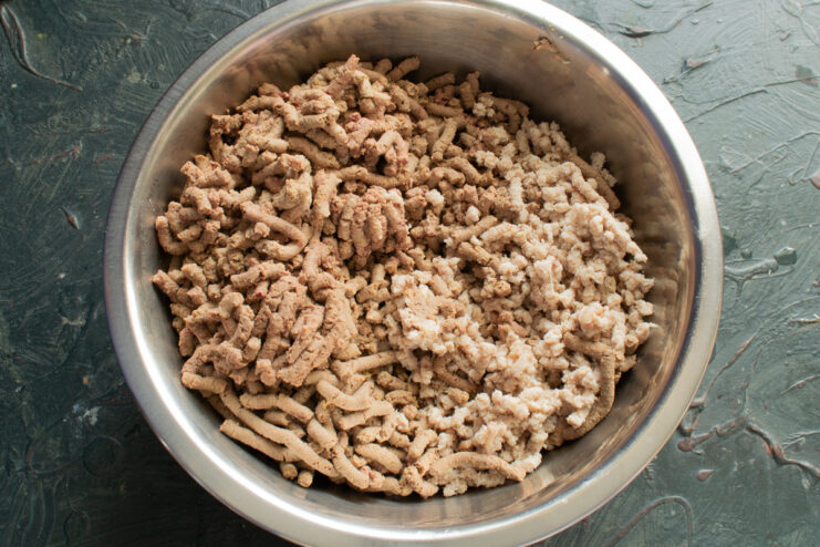 Combining The Meats Mixing ground chicken and ground liver in a bowl