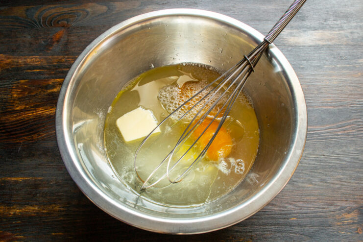 Mixing Liquid Dough Base Whisking eggs, oil, and water together in a metal bowl