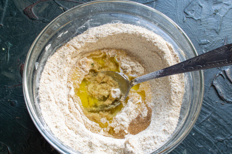 Starting to mix the batter Mixing an egg into the flour with a spoon