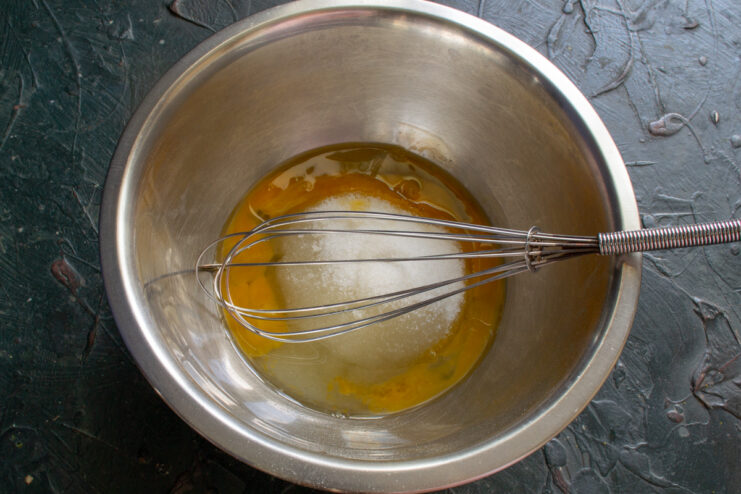 Starting the batter Mixing egg yolks, sugar, and oil in a bowl for the cake batter
