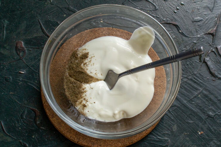 Sour cream sauce base Sour cream mixed with spices in a glass sauce bowl.