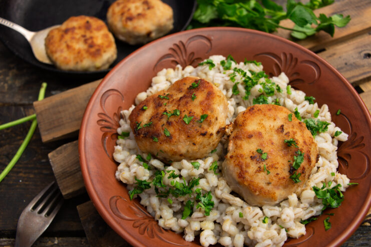 Juicy homemade pork and chicken patties served with pearl barley garnish