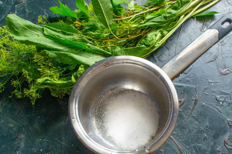Measuring the pickling salt Measuring coarse salt into a large pot to prepare the pickling brine