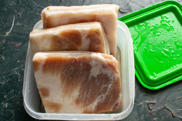 Curing process Salted salo chunks curing inside a plastic container