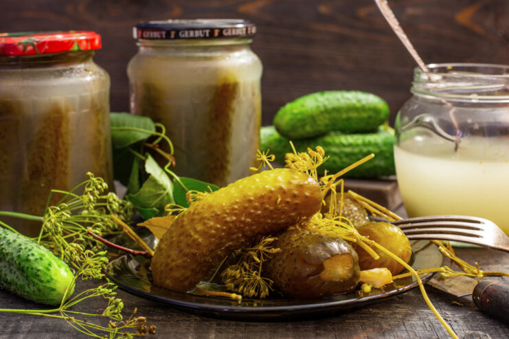 Canned fermented pickles in a glass jar and served on a plate