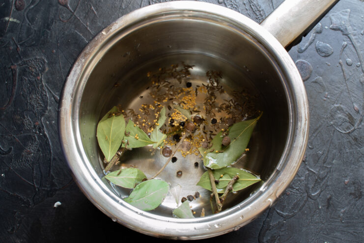 Boiling the aromatic brine Spices, bay leaves, and mustard seeds boiling in a saucepan