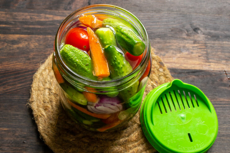 Glass jar of vegetables covered with a draining lid