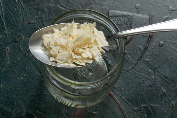Reviving dry starter One tablespoon of dry sourdough starter flakes above a glass jar