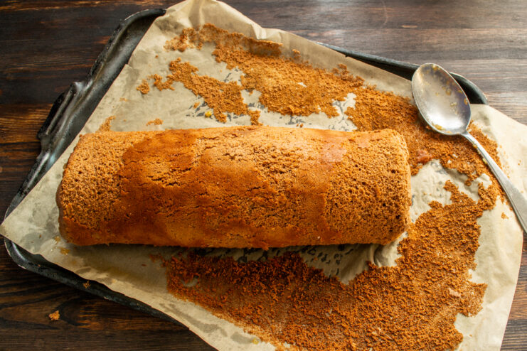 Rolled Cake With Filling Filled chocolate cake rolled up tightly on parchment paper