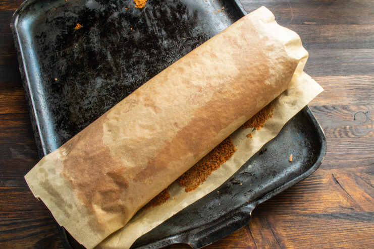 Rolling the Sponge Hot chocolate sponge cake being rolled up with parchment paper