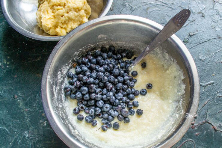 Adding fresh blueberries into the filling Pouring fresh blueberries into a creamy ricotta filling in a bowl