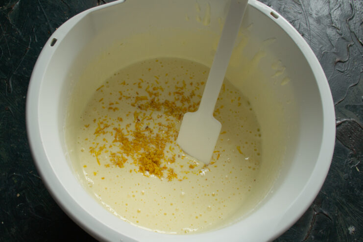 Adding lemon zest Freshly grated lemon zest on top of the egg mixture