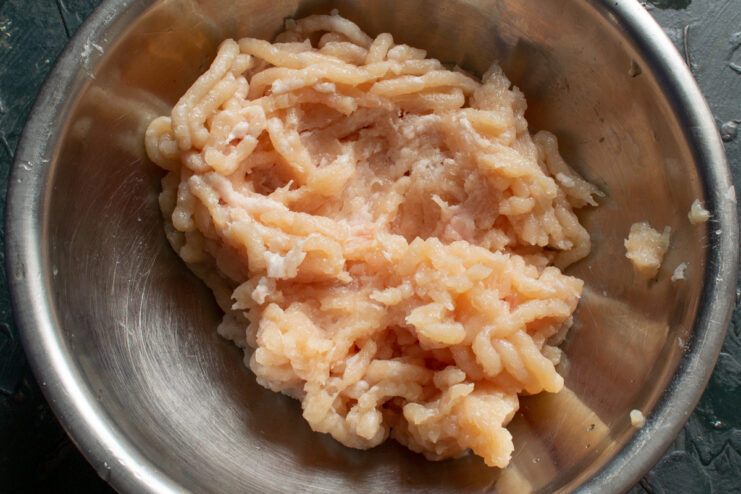 Freshly ground chicken mixture in a stainless steel bowl