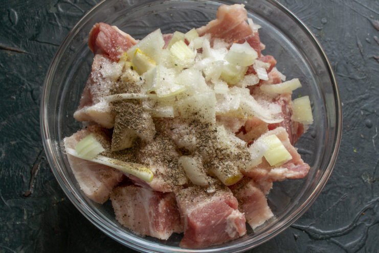 Seasoning the tushenka Pork and onions seasoned with salt and black pepper
