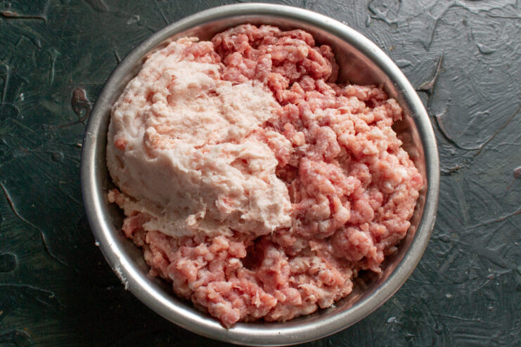 Grinding the pork Ground pork in a metal bowl after grinding