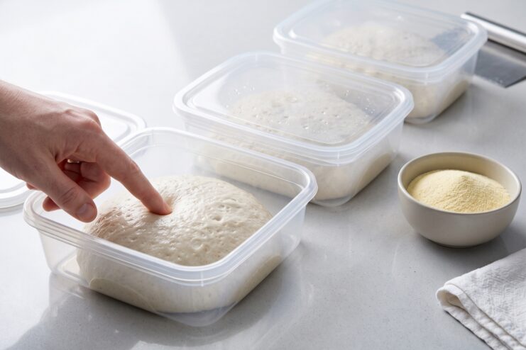 Cold Fermentation of Pizza Dough Pizza dough in clear plastic containers during cold fermentation.
