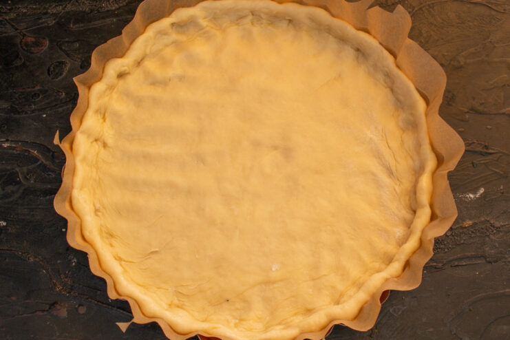 Shaping the cheesecake crust Rolled out dough shaped with edges inside a baking pan