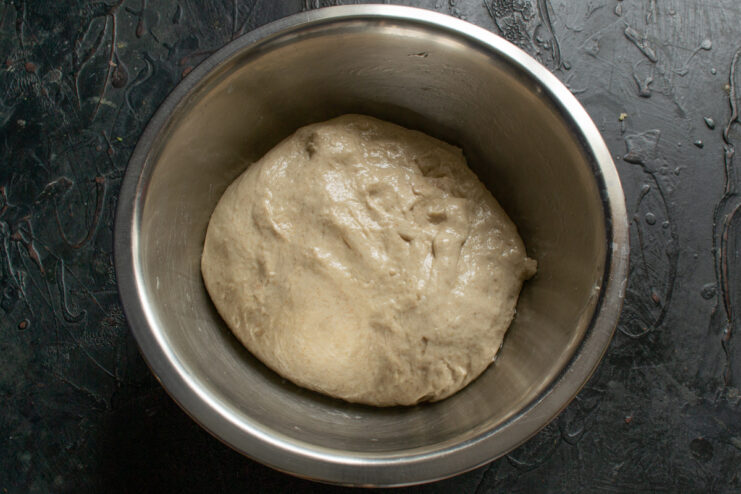 Transferring dough to bowl Kneaded dough resting in an oiled metal bowl before fermentation
