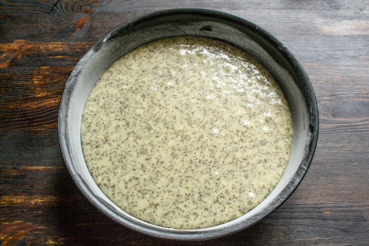 Pouring batter into the dish Pouring poppy seed cake batter into a round greased baking dish