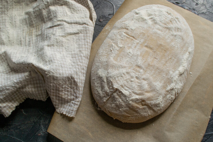Turning loaf onto parchment Proofed bread loaf turned out onto a sheet of baking parchment
