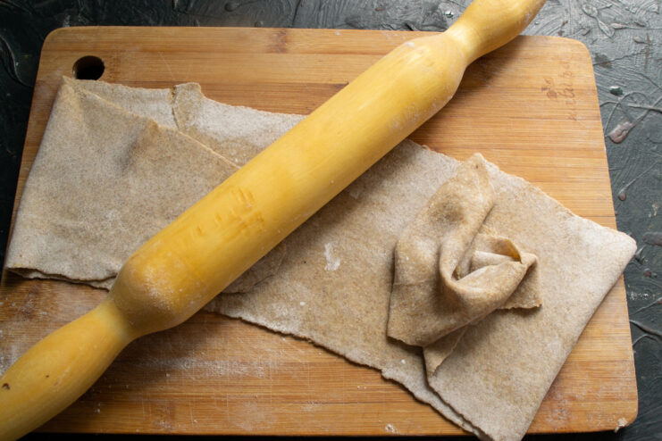 Checking the dough thickness A very thin sheet of rolled rye dough resting on a floured cutting board