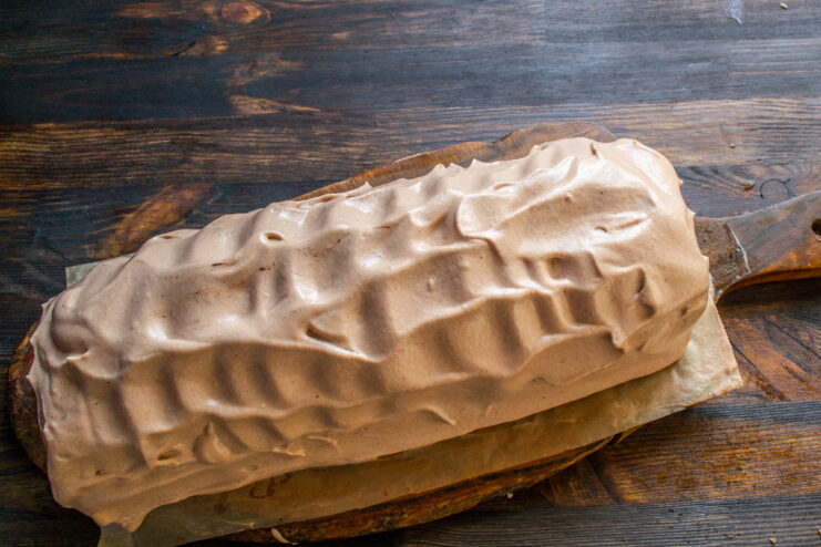 Frosting the Cake Chocolate cake fully coated in frosting with a wavy texture