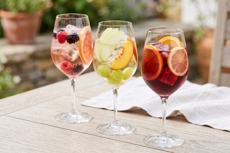 Three glasses of different sangria variations: white, rosé, and red
