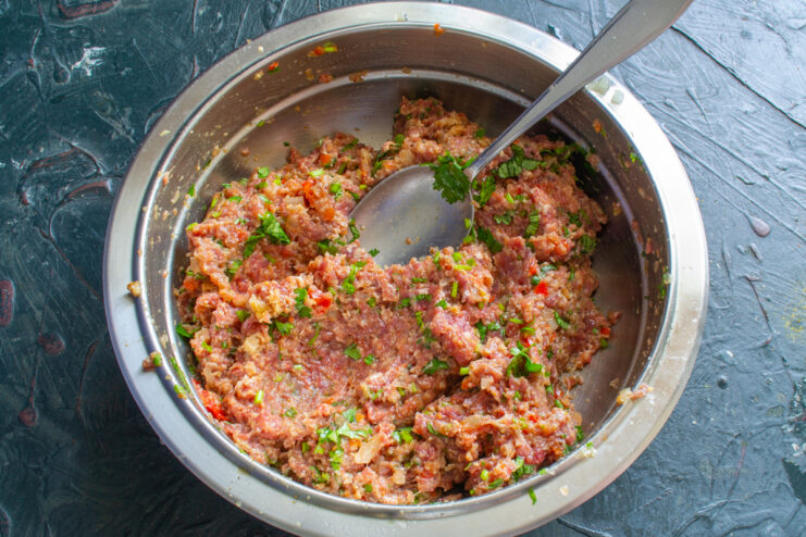 Prepared meat mixture Thoroughly mixed ground meat with spices and herbs in a bowl