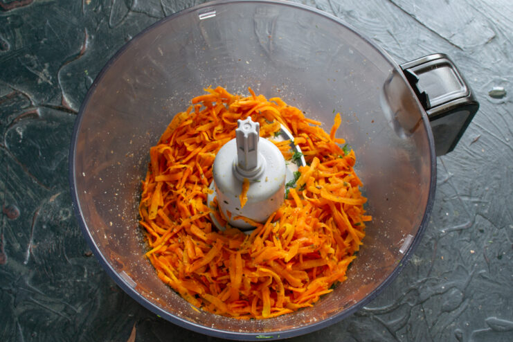 Mixing carrots and walnuts Braised carrots added to the ground walnuts and herbs in a food processor