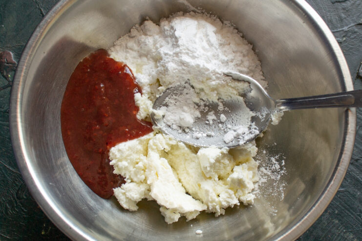 Cream ingredients Soft farmers cheese powdered sugar and raspberry jam in a bowl