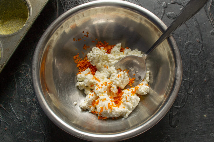Mixing cheese and mandarin zest Mixing full-fat farmers cheese with mandarin zest and juice in a bowl