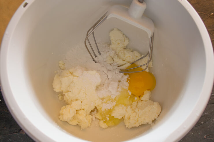 Ingredients for the cheese filling Farmer's cheese, eggs, and sugar in a mixing bowl