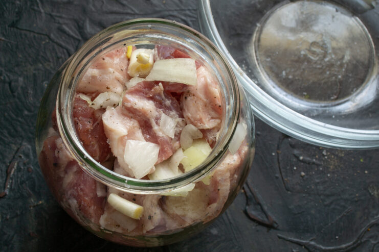 Filling the jar Packing seasoned pork and onions into a glass jar