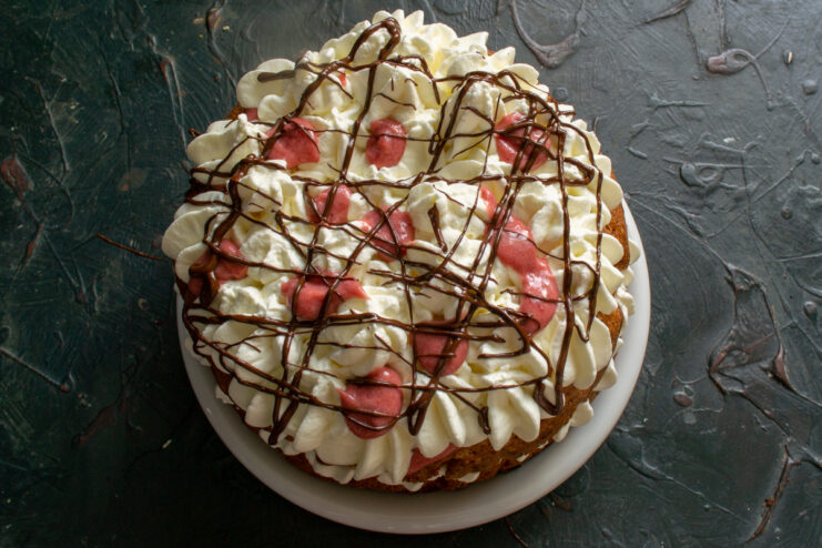 Decorating the finished cake Decorating the cake with whipped cream and drizzled melted chocolate