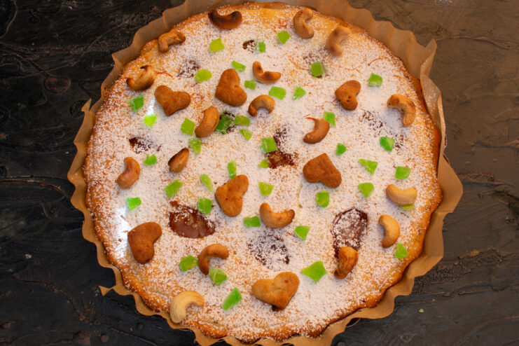 Decorating the baked cake Cheesecake decorated with powdered sugar, nuts, and candied fruits