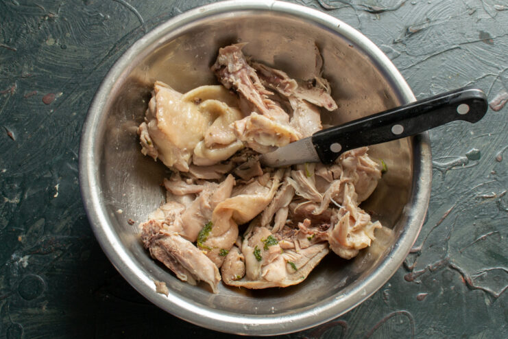 Prepping The Chicken Cooked deboned chicken meat with skin in a bowl